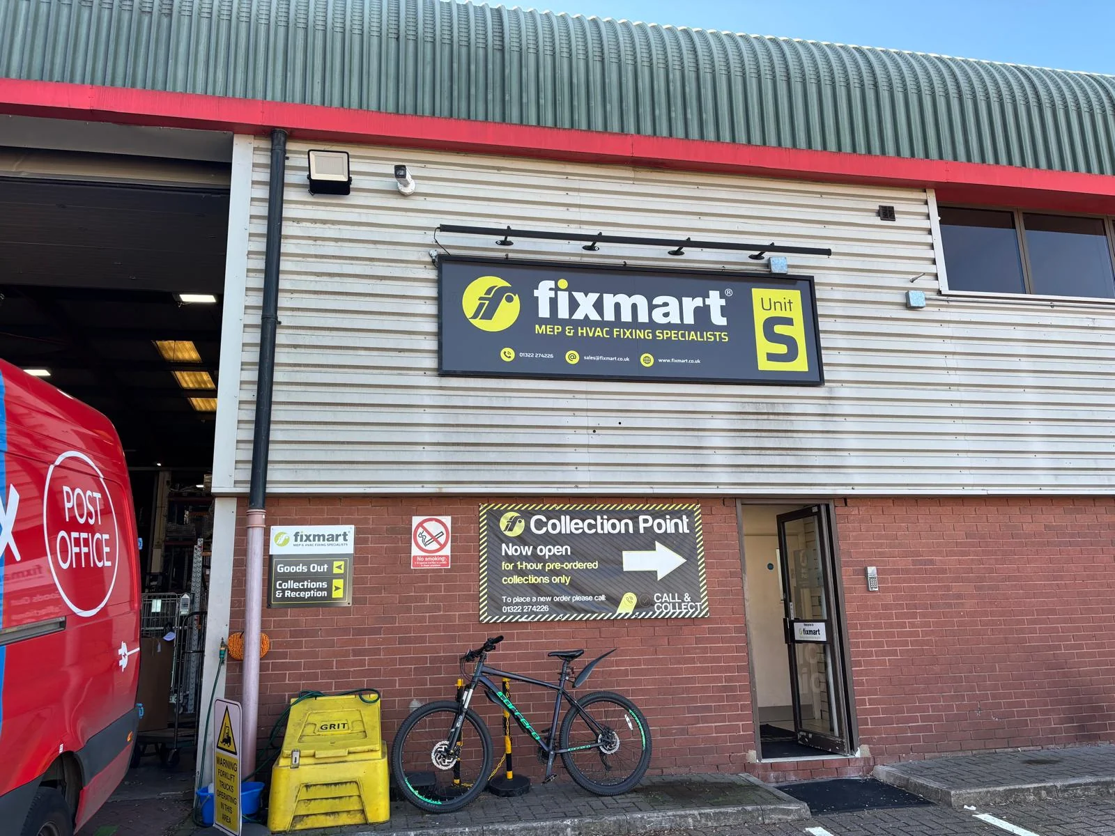 Fixmart Unit S aluminium sign tray with yellow and white graphics, trough lighting above and directional signs below